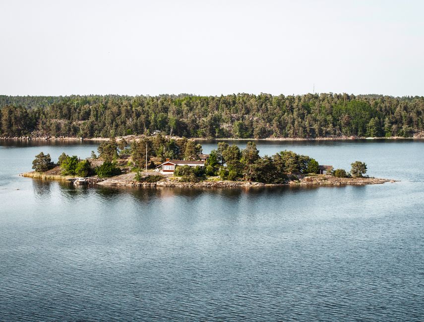 A tranquil island with cottage surrounded by calm water in Stockholm Archipelago.